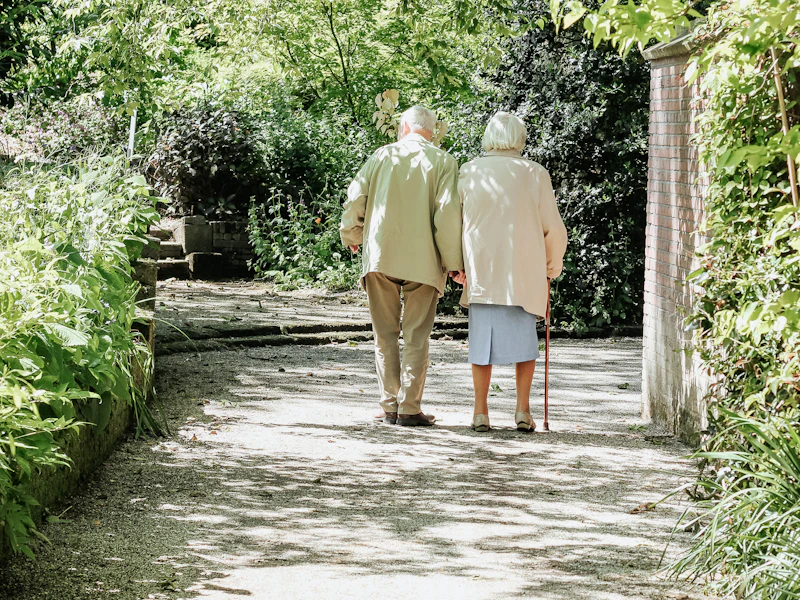 An older couple walks together outdoors
