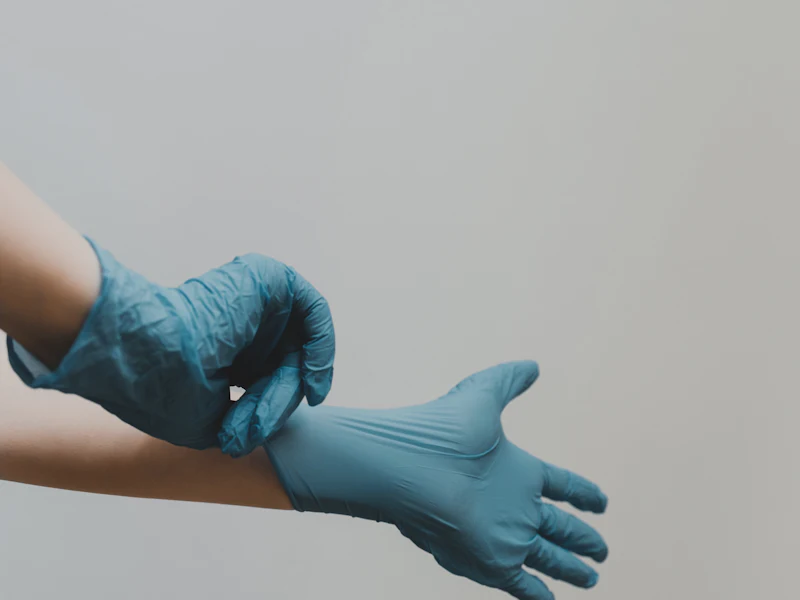 A wound care nurse puts on clinical gloves before a dressing change