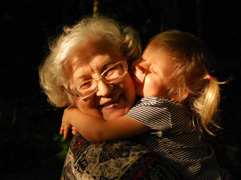 A grandmother embraces her granddaughter, smiling warmly