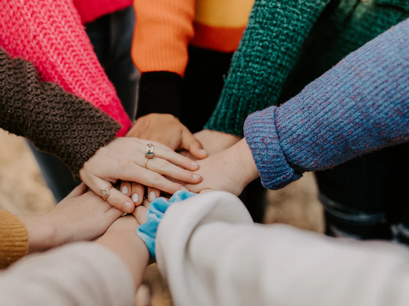 The hands of a care team stacked together