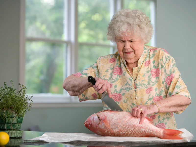 A senior woman prepares her favorite recipe during a companion care visit